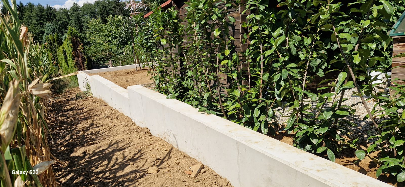 Lange Betonstützmauer entlang der Grundstücksgrenze